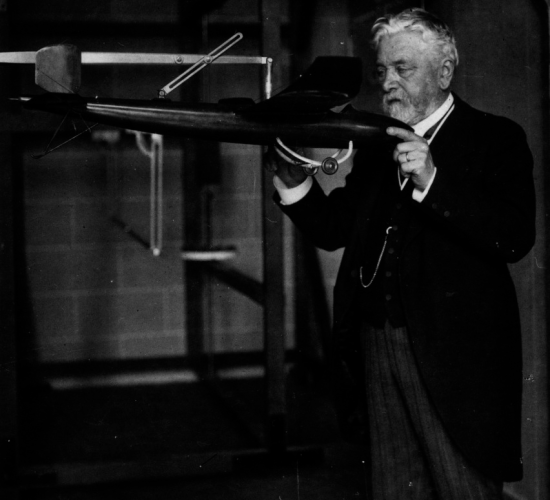 Gustave Eiffel in his laboratory holding a model of the airplane designed by Victor Tatin